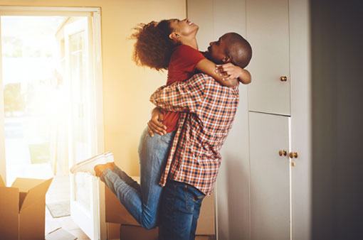 Couple embracing in their new home.